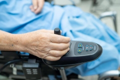 Elderly old lady woman patient on electric wheelchair with remote control