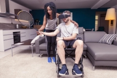 Young girl helps a disabled man who plays tennis with augmented reality viewer