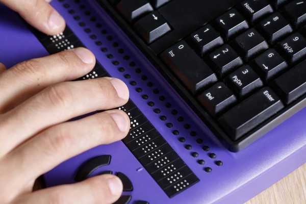 Blind person using computer with braille computer display