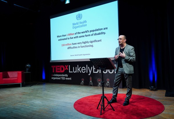 Clive giving his Ted Talk. Behind him, a screen says 