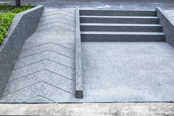 A concrete ramp next to a concrete stair on a University Campus