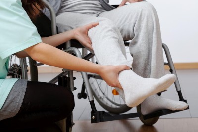 Young physiotherapist exercising with elderly disabled person